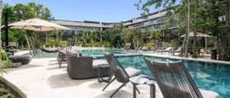 AWA's upscale community pool with umbrellas, lounge chairs, kids club & hot tubs