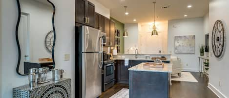 Open concept kitchen with stainless steel appliances and bar seating.