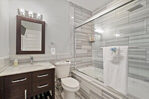 Nice clean modern bathroom with shower, jetted tub, toilet, vanity and TV.  
