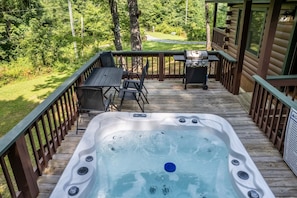 Hot tub - Hot tub on deck with seating area and gas grill.
