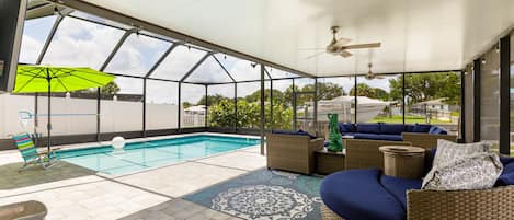 Large covered lanai with seating, fans, tv, pool, and hot tub.