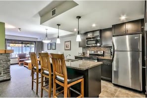 Modern fully-stocked kitchen with island and dishwasher.