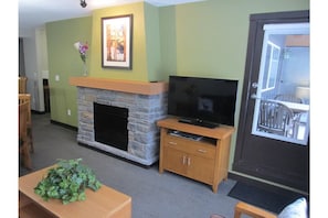 Gas fireplace, cable TV and exit door to the patio is shown