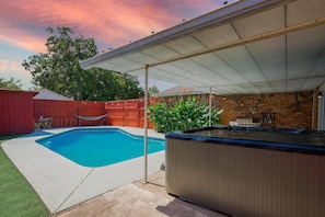 Poolside Vibes - Unwind poolside with string lights, a hammock, jacuzzi and tropical plants adding to the chill vibe.