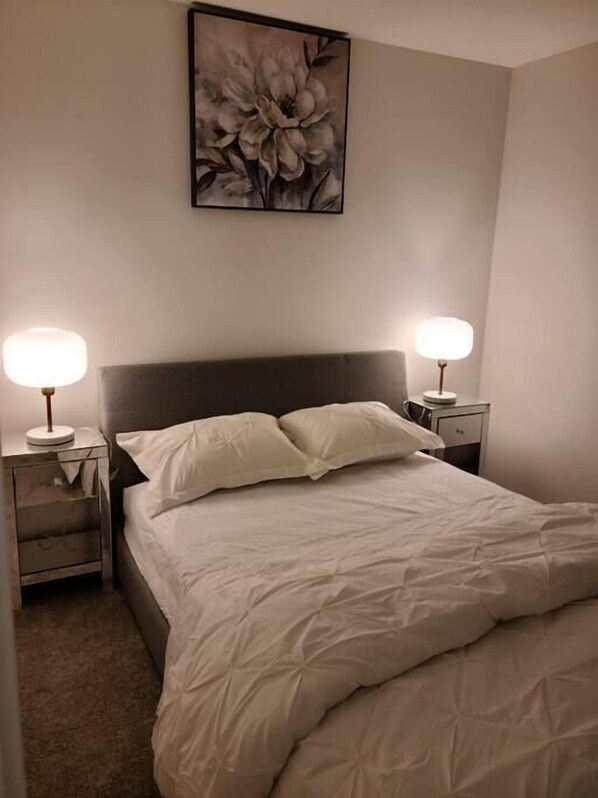 A Bedroom with King Size bed and both side lamp on the table