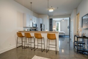 Fully equipped kitchen with stainless steel appliances, breakfast bar seating, and fully stocked with your basic cooking essentials.