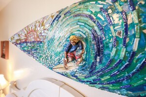 The condo has been beautifully decorated and brings the nearby ocean and beach inside through the teal color accent and other decor like this mosaic piece in the mater bedroom.