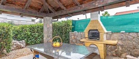 überdachte Terrassensitzgruppe mit Grillkamin