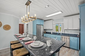 Fully-stocked kitchen with breakfast bar, seats 4.