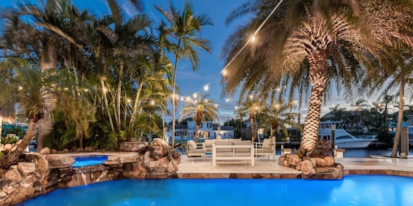 Waterfront Resort Style Oasis with Salt Water Heated Pool, Spa,  FIre Pit, Tiki Hut & Bar, Outdoor Kitchen, Outdoor Dining Area, 80' Deep Water Dock / Floating Dock with no fixed bridges to Intercoastal.  Plenty of Seating Areas, a Hammock & much mor