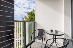 Balcony with a small table and chairs, ideal for enjoying the fresh air and surrounding views.

