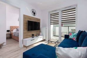 A modern TV unit with a wooden finish in a bright living area.