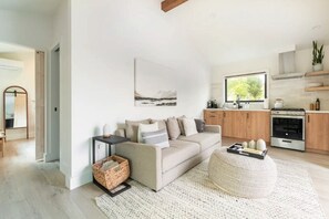 Light, bright and airy open living area with exposed beam cathedral ceiling