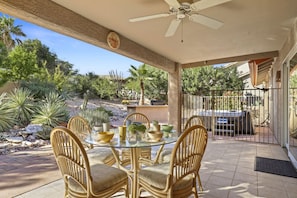Covered backyard patio with dining, grill, and hot tub!