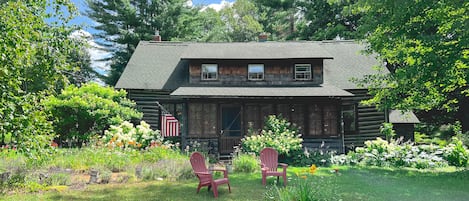 Front of cabin with original exposed logs and sun porch. 