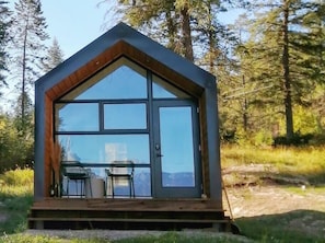 A modern tiny home, surrounded by forest and mountains.