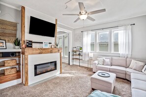 Living room entry with 55" Smart TV, electric fireplace, and huge sectional.