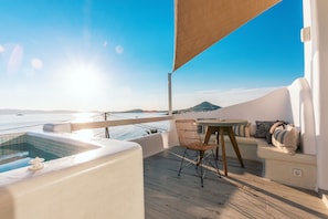 Private balcony of the flat with a hot tub, pouch chair and a panoramic sea view
