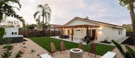 Private backyard with fire pit, hot tub, outdoor dining and lounge areas.