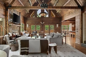 Living room with vaulted ceilings, fireplace, and seating for your entire group.