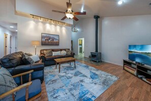 Living room with smart TV, wood-burning fireplace, and comfortable seating