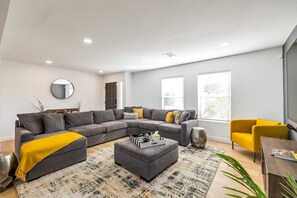 Living room w/ Large sectional sofa, chair and 85" smart TV with Youtube Live