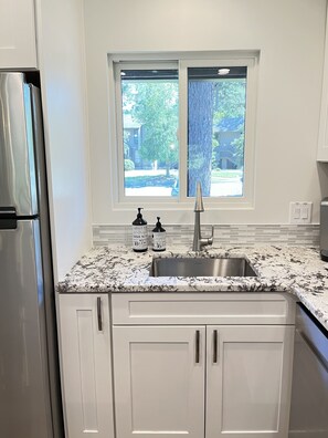 Kitchen with full size refrigerator, Keurig coffee maker, oven, and microwave.