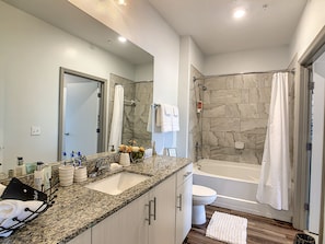 Indulge in luxury and space in our expansive bathroom with generous countertops.