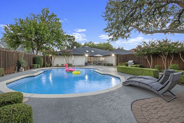 Relax poolside with loungers, a sparkling pool, and lush landscaping!