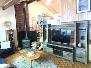 Living room looking up to the kitchen area with pine vaulted ceiling.