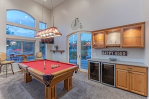 The dedicated game room has an exciting pool table, newly added foosball, TV and beverage bar.