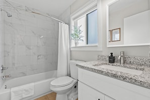 Luxury Bathroom Featuring Porcelain Tile, Granite Countertops, and Plush Towels