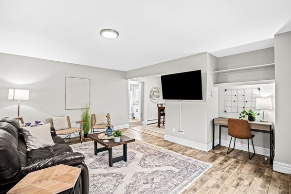 Open living space includes 55in ROKU Smart TV and Workspace