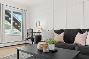 Relax in style or catch up on work in this bright, cozy living space with a dedicated desk area.