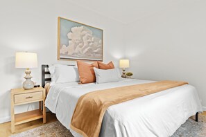 Unwind in this calming bedroom retreat featuring a plush king bed and soft, natural tones.