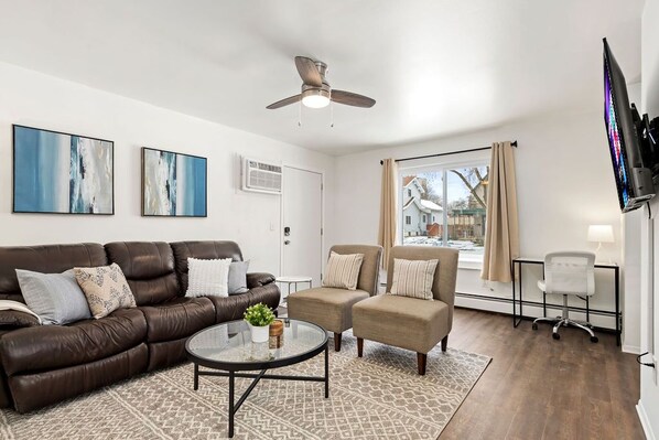 Comfy living space with work desk and mounted Smart TV