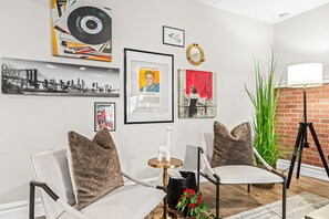 Cozy up in this charming living room with a good book and a cup of coffee. The brick wall adds a touch of warmth, and the lamp provides a soft glow. The perfect place to relax and unwind after a long day.