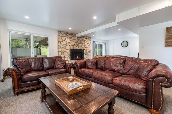 The living room provides the perfect space to relax and unwind. Enjoy entertainment on the wall-mounted TV with access to Netflix, cozy up by the gas log fireplace, and sink into the comfortable furniture designed for your ultimate comfort.