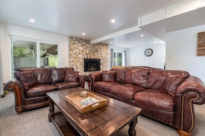 The living room provides the perfect space to relax and unwind. Enjoy entertainment on the wall-mounted TV with access to Netflix, cozy up by the gas log fireplace, and sink into the comfortable furniture designed for your ultimate comfort.
