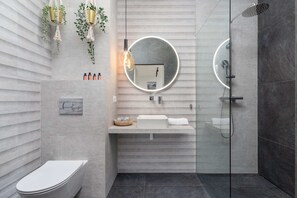 Contemporary bathroom featuring a walk-in shower, decorative tiles, and elegant lighting.
