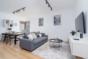 Open-concept living and dining area with modern furnishings and a large window for natural light.
