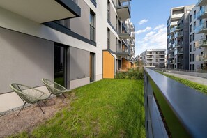 Outdoor space with a green lawn and patio chairs, perfect for relaxation.
