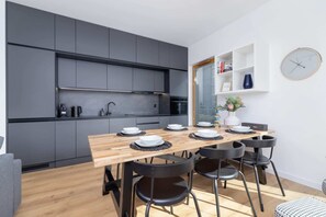 Dining area with a minimalist table setup and sleek black cabinetry in the background.

