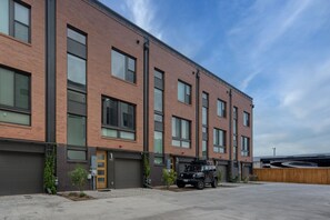 Two townhomes with identical floorplans are 100 feet apart in adjacent buildings within the same gated community