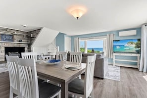 open kitchen & living room with sleeper sofa, 50" smart TV, high-efficiency mini-split for AC/heat, and stunning views of the ocean.