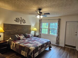 Master bedroom with a king size foam bed, access to balcony, TV and private bath