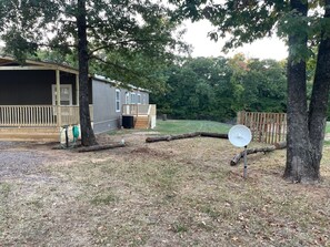 View of the backdoor entrance with deck.  RV parking and set up while you stay. 