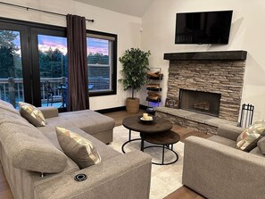 Living area with French doors to the deck and cozy fireplace.