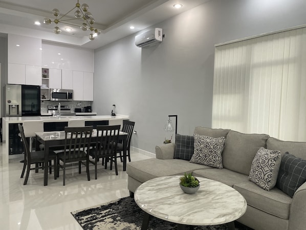 Living room with sofa bed and dining area.