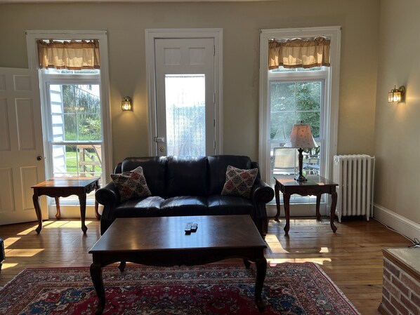 Main living room filled with lots of natural light! Classic Victorian detail with floor to ceiling windows.